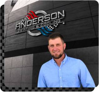 Jake Anderson standing in front of Anderson Heating & Cooling sign