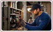 Technician repairing furnace in basement of Central Kentucky home.